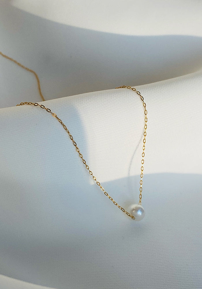Solitaire Perlenkette aus Gold mit schwingender Süßwasserperle am Schlüsselbein getragen - SimplyO